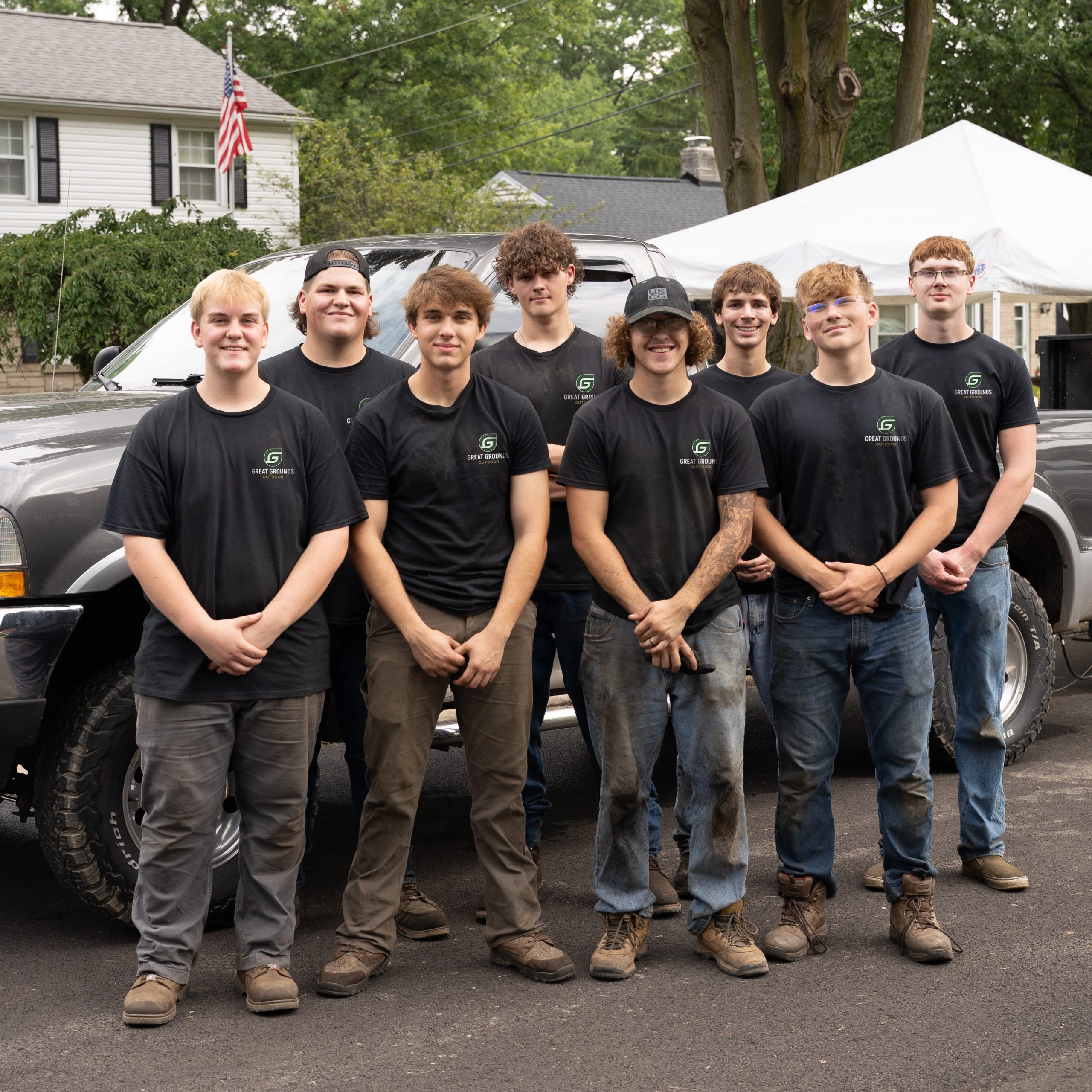 The Great Grounds Outdoor team standing together in front of their work trucks
